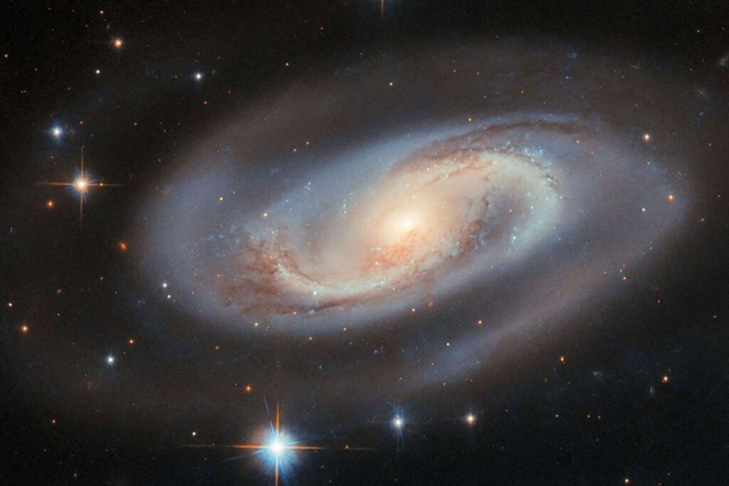 O lar dos monstros. No coração de galáxias majestosas como esta, a Via Láctea, astrônomos descobriram que um buraco negro supermassivo atua como uma âncora gravitacional, ditando o balé de bilhões de estrelas ao seu redor.